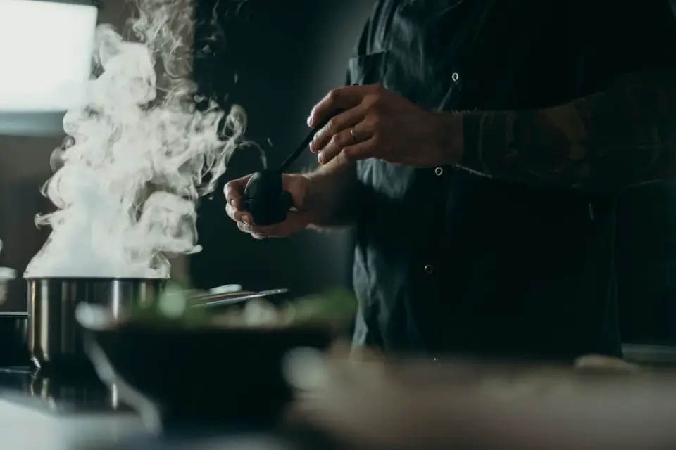 A dog eating from a bowl with steam rising in a home kitchen