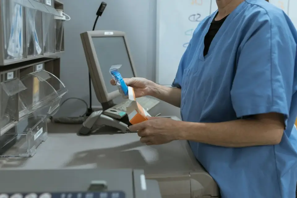A veterinarian holding two different dog probiotic chew bags side by side on a stainless exam table