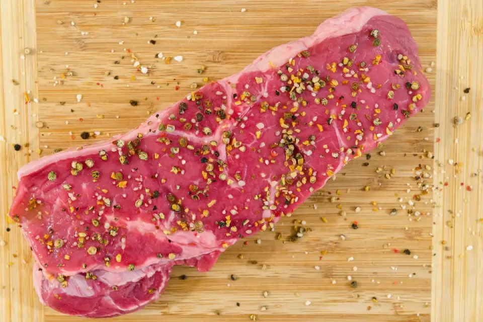 Raw green beef tripe on a wooden cutting board